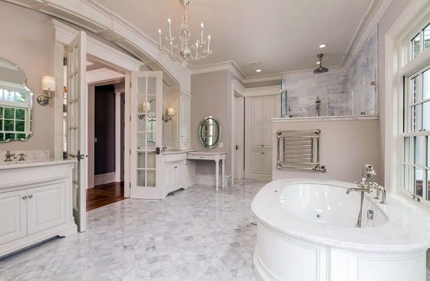 Luxury white bathroom with marble floors and tub enclosure with chandelier