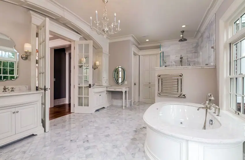 Luxury white bathroom with marble floors and tub enclosure with chandelier