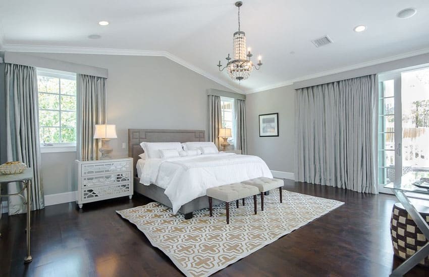 Master bedroom with silver wall covering and decor with walnut floors