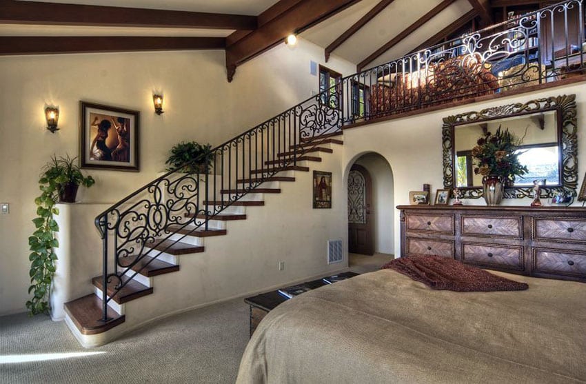 Mediterranean style loft bedroom with stairs leading to a sitting area