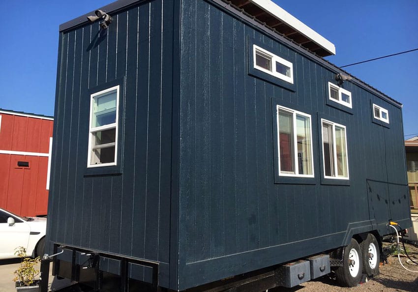 Portable tiny wood siding house painted dark blue