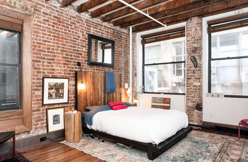 Rustic brick loft bedroom with wood flooring and exposed beam ceiling