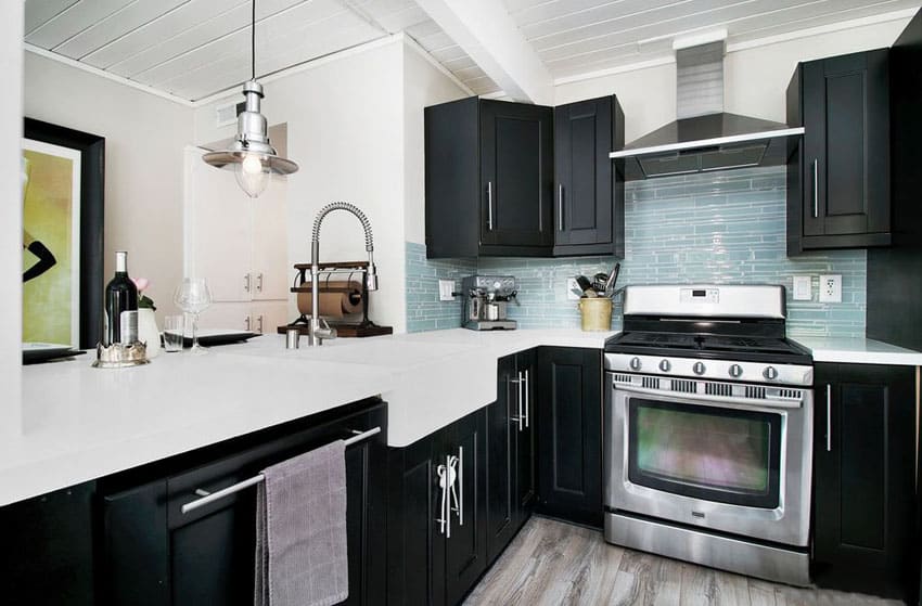 Small kitchen with black cabinets, arctic white cabinets and blue glass backsplash