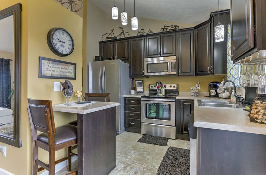 Small traditional kitchen with dark raised panel cabinets and one person dining peninsula