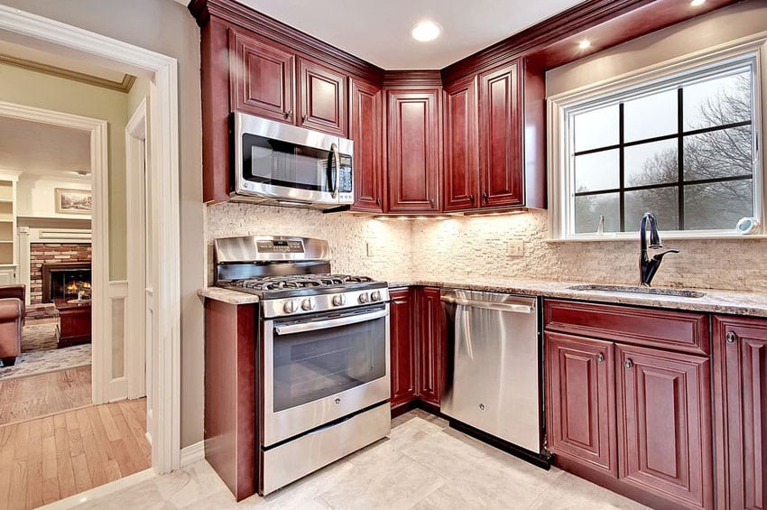 Small traditional l shaped style kitchen with dark red cabinets and stone backsplash
