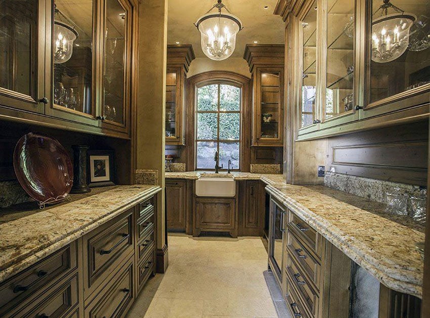 Traditional kitchen with custom wood cabinets, cream granite counters and travertine floors