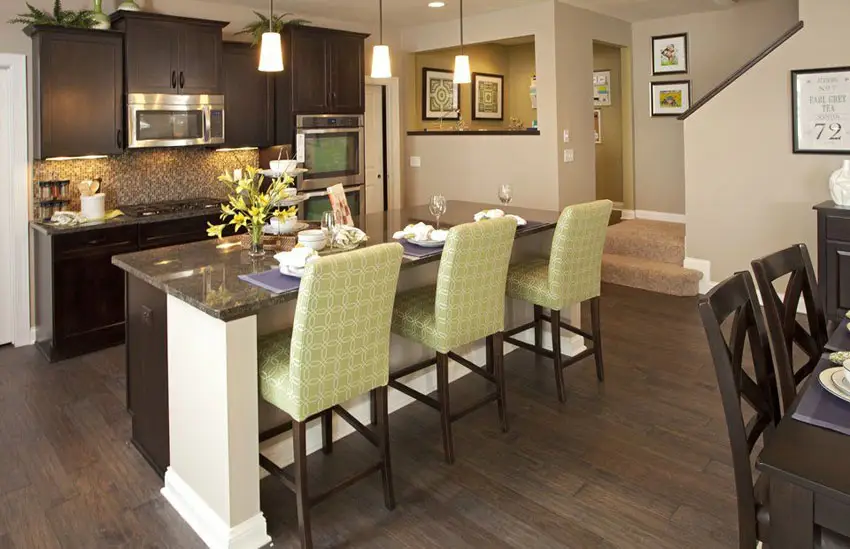 Kitchen with wooden flat panel cabinets and green upholstered chairs