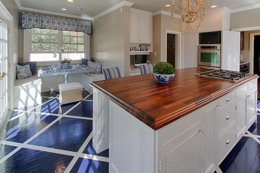 Traditional kitchen with white cabinetry, custom wood counters and window seat bench