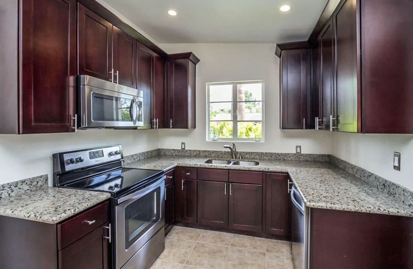 U shaped kitchen with dark shaker cabinets and granite counters