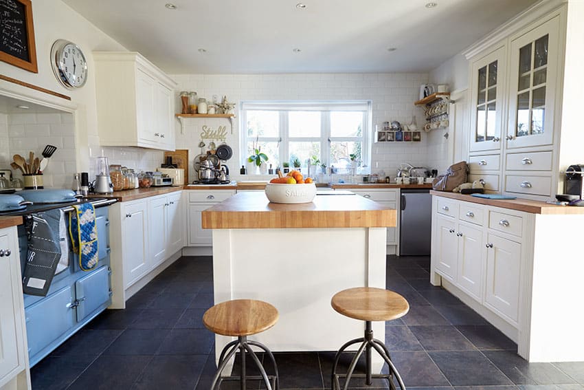 White cabinet kitchen with light wood counters and vintage blue oven