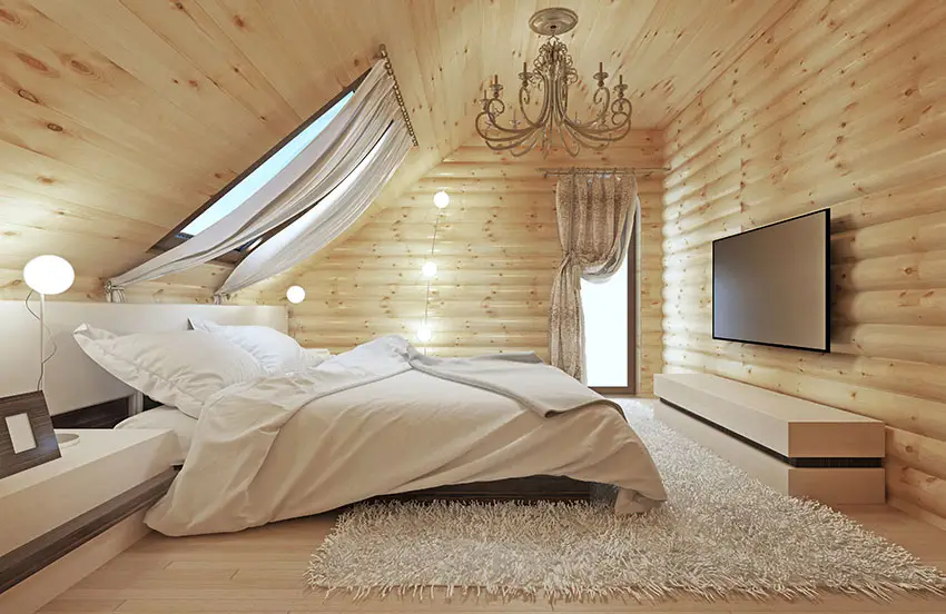 Wood walled loft bedroom with skylight above bed