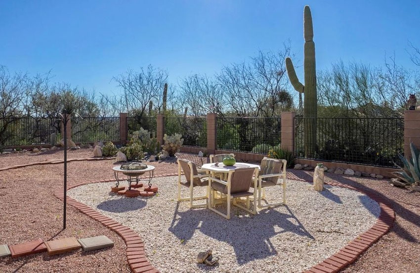 backyard landscape with red and white pea gravel and brick border