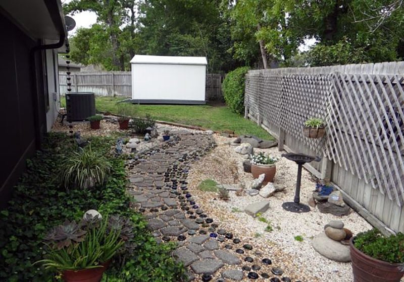 Backyard with walkway of stone pavers and glass bottles