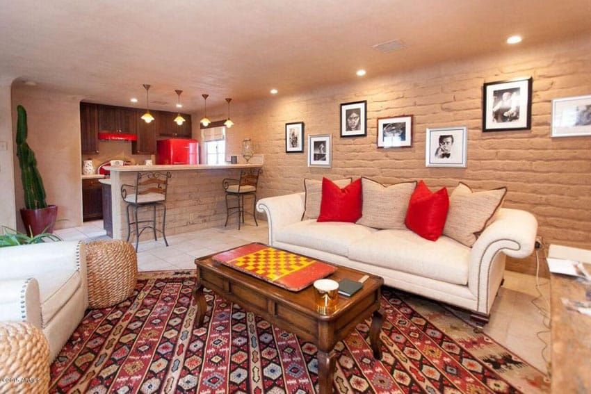 Basement with stone wall wet bar comfortable furniture and artwork