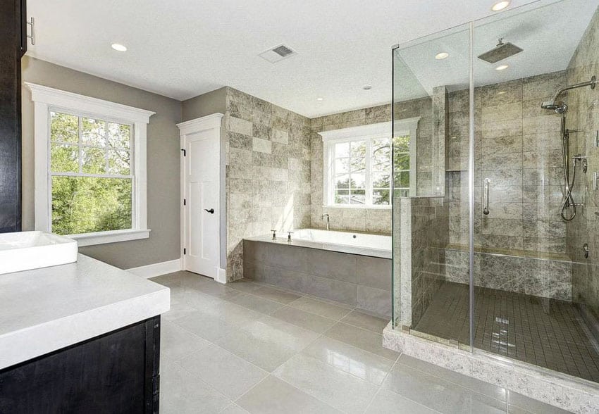 Bathroom with glass frameless shower with travertine tile and rain showerhead