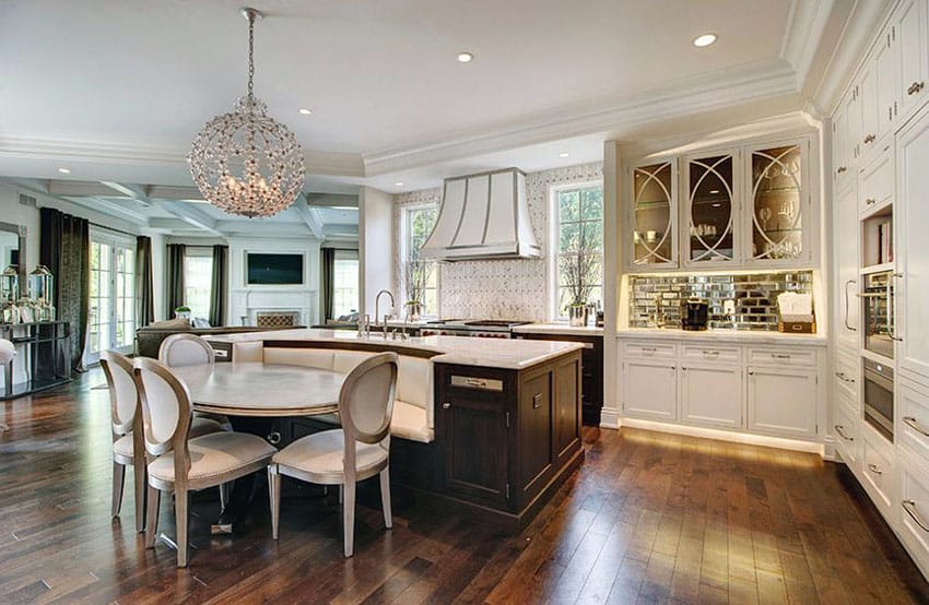 Beautiful kitchen with white flat panel cabinets and dark wood island with bench seating