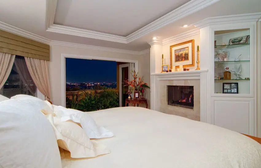 Bedroom with fireplace and city view