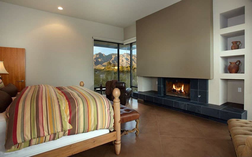 Bedroom with large black fireplace and mountain view