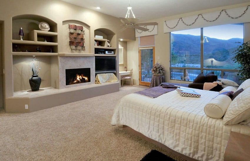 Bedroom with built-in niche fireplace and hillside view