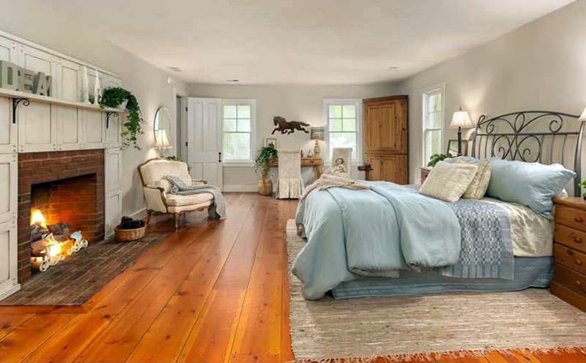 Country bedroom with panel fireplace and knotty floors