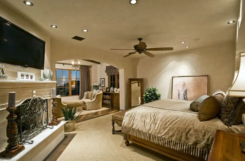Grand bedroom design with window seating nook and stone fireplace