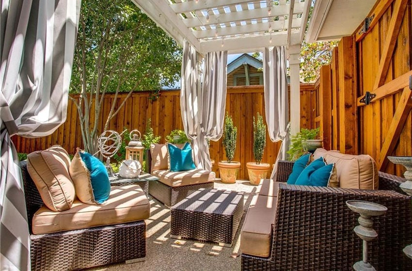 Gravel patio under white pergola with outdoor table and chairs