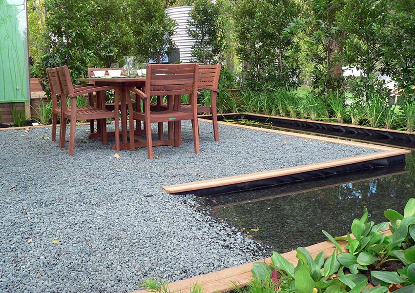 Gravel patio with water feature pond and outdoor dining table