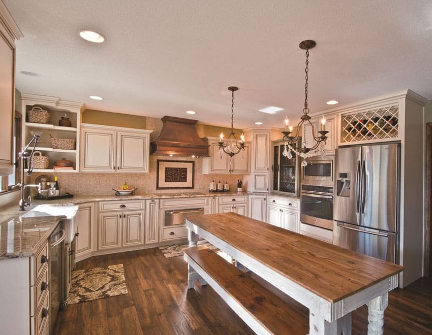 Kitchen with antique white cabinets and portable rustic wood island with wood top dining bench