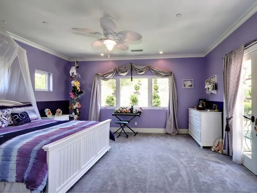 Lavender color kids room with white canopy bed and furniture