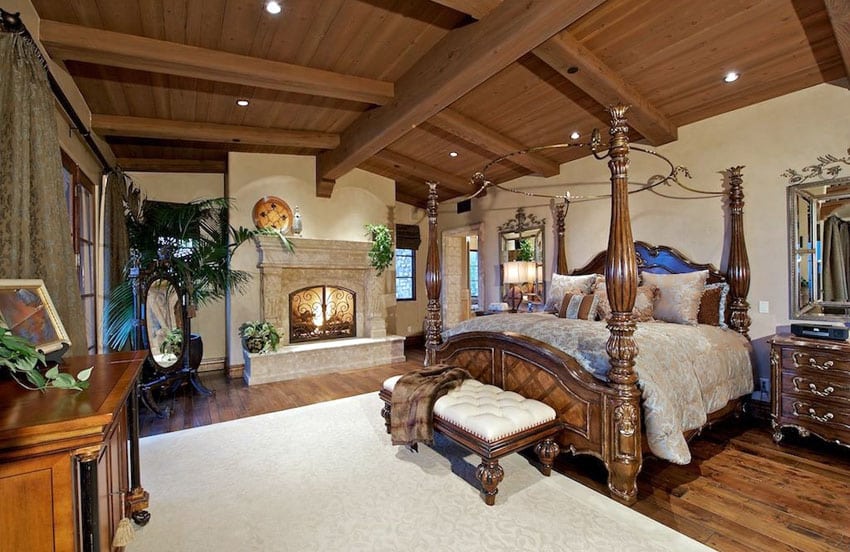 bedroom with exposed beam ceiling and custom fireplace
