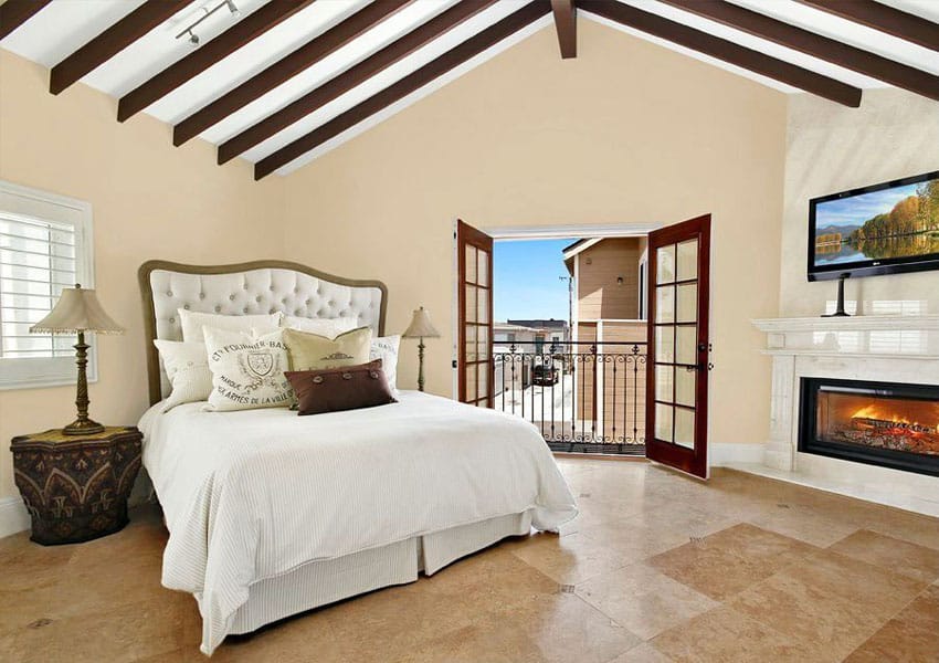 Mediterranean master bedroom with fireplace, arched ceiling and outdoor balcony views