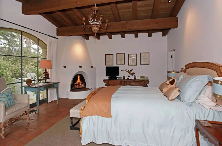 Mediterranean master bedroom with fireplace and terracotta tile floors