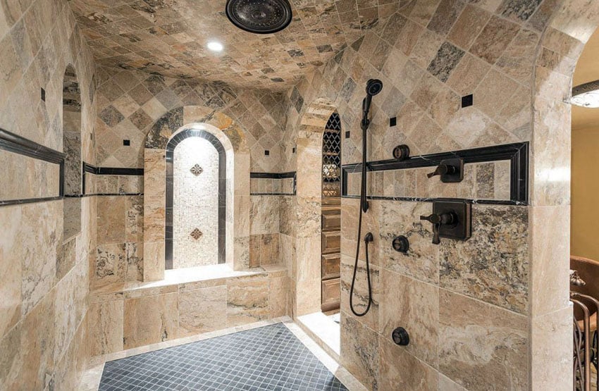 Mediterranean shower with travertine tile walls and marble floor tile with bronzed hardware and rainfall showerhead