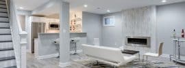 modern-basement-living-room-with-small-kitchen-porcelain-tile-floor-and-white-furniture-with-fireplace
