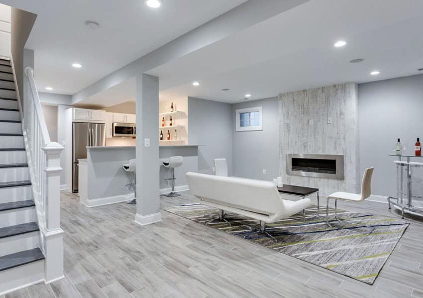 Modern basement living room with small kitchen porcelain tile floor and white furniture with fireplace