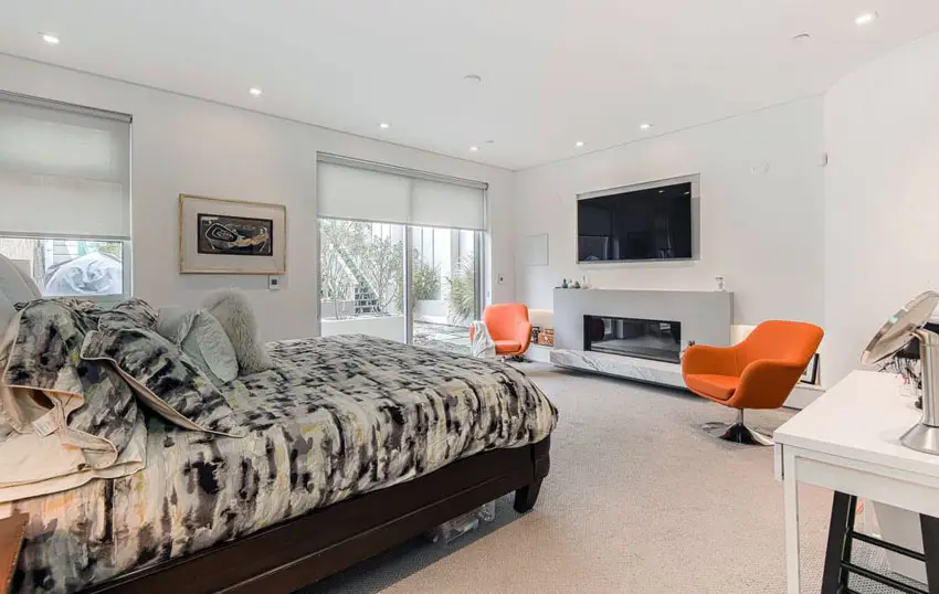 Modern master bedroom with gas fireplace with marble base
