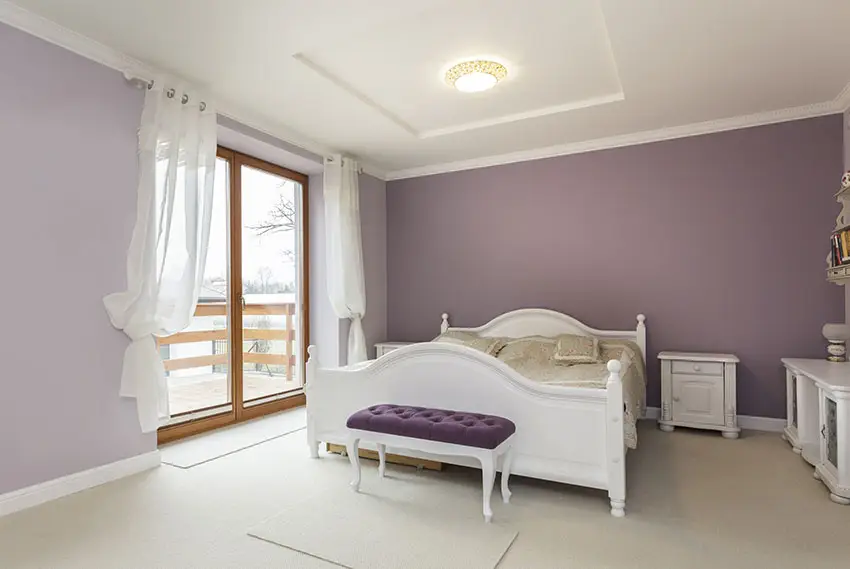 White and purple themed bedroom with white furniture and balcony