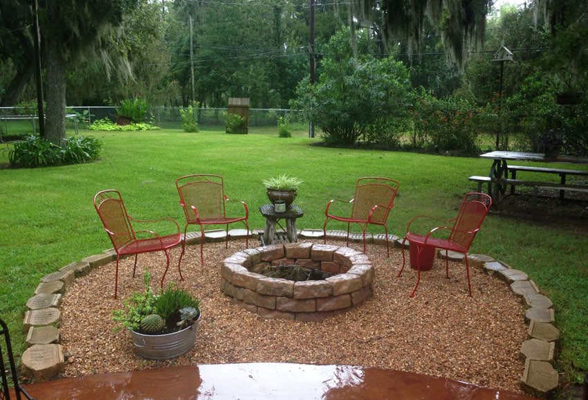 Round rough gravel patio with stone fire pit