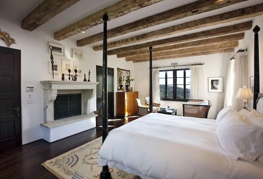Rustic master bedroom retreat with decorative fireplace
