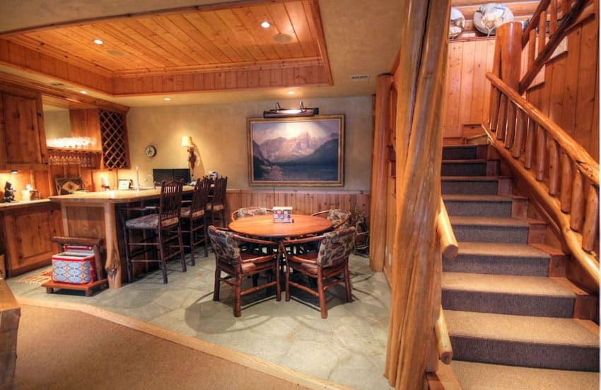 Rustic wood basement with home bar and stone flooring