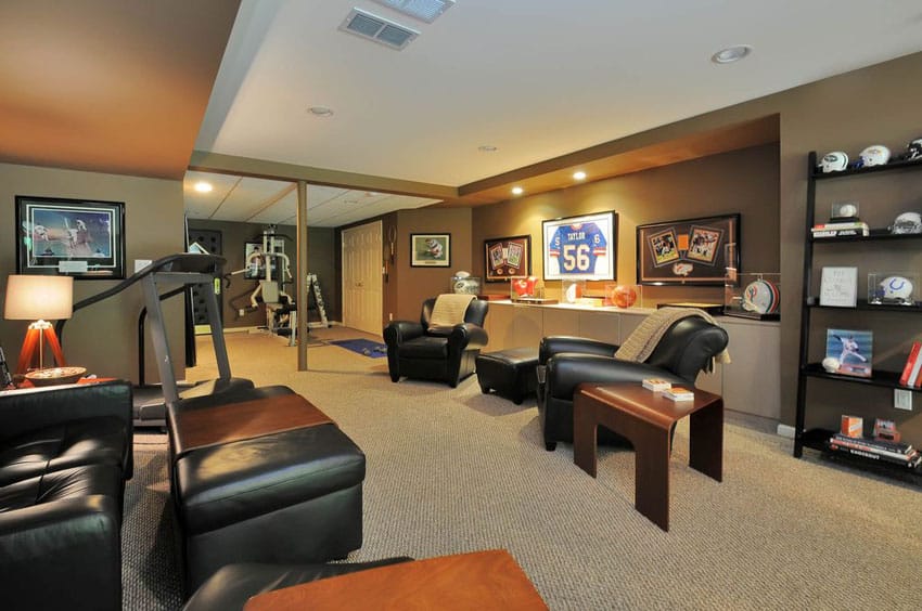 Sports room basement with leather furniture and football baseball team decor