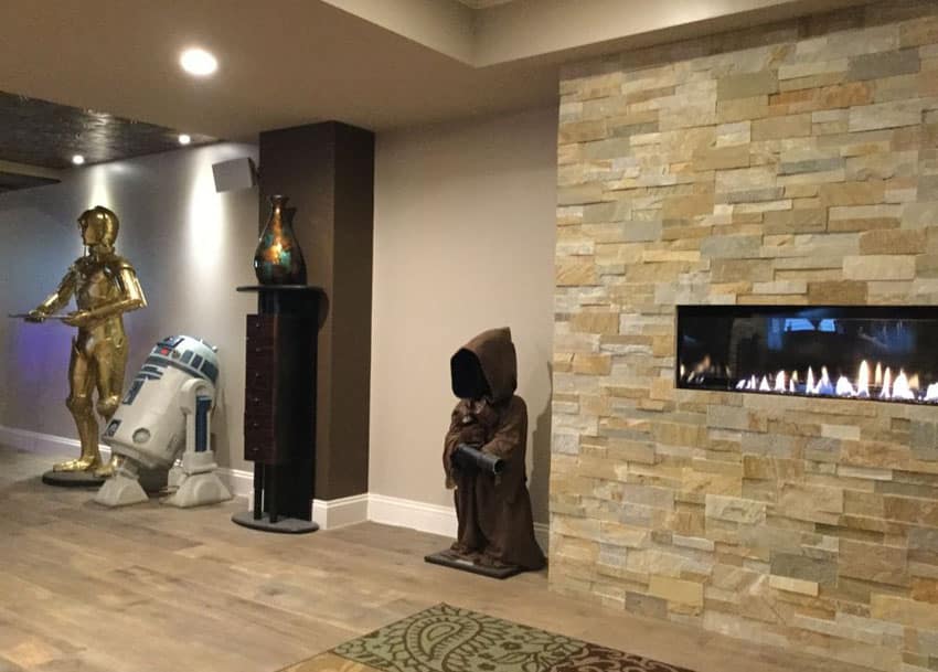 Star wars decor in basement room with wood floors and fireplace