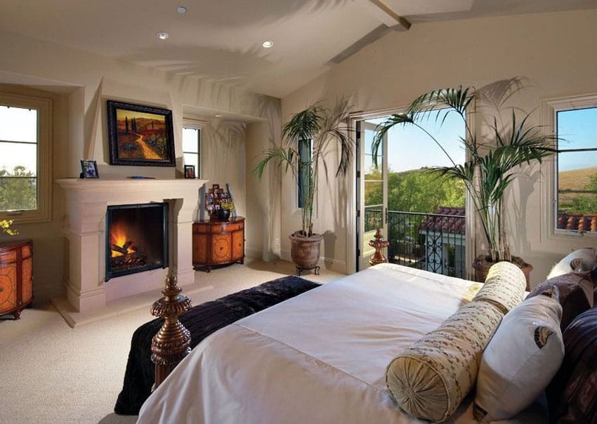 Traditional luxury master bedroom with fireplace facing bed