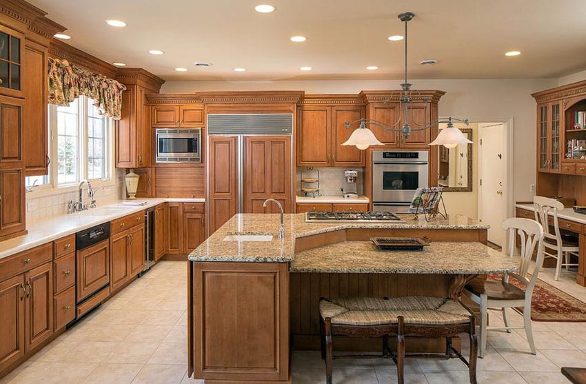Traditional kitchen with granite top, l shaped island with lower breakfast bartop, and two seater bench