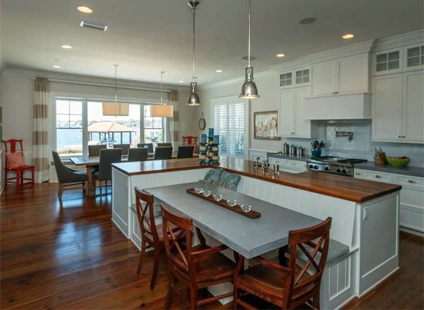 traditional kitchen with l shaped island wood counter with attached bench and dining table