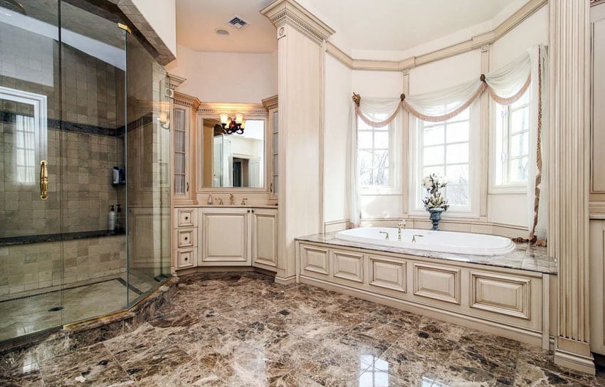 Traditional luxury bathroom with rough travertine enclosure and large enclosed tubs