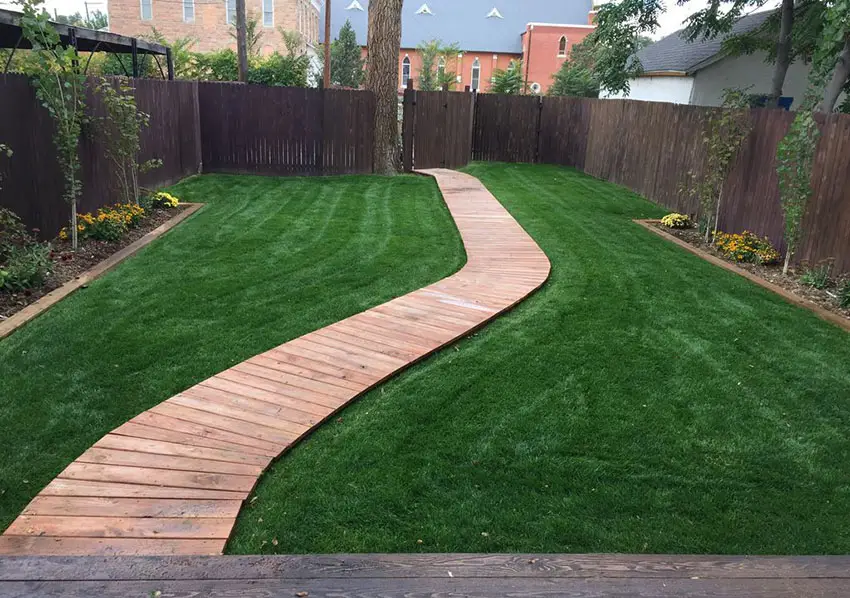 Wood deck walkway through backyard lawn