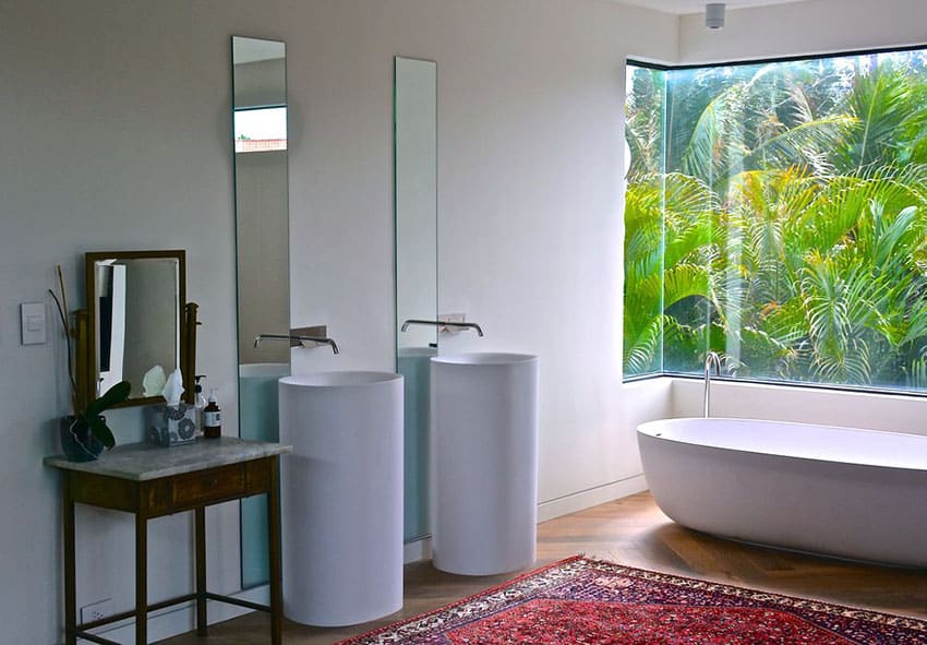 Beautiful master bathroom with acrylic tub and modern pedestal sinks