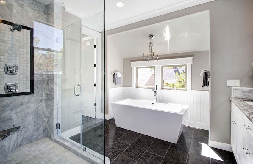 Bathroom with wainscoting, glass enclosure and black floor tile