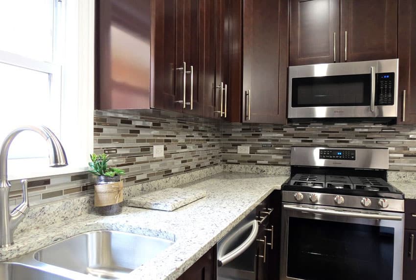 Contemporary kitchen with giallo verona countertop glass mosaic backsplash and dark cabinets